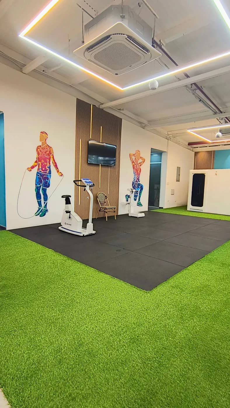 Área de ejercicio terapéutico con césped y luces LED en Park and Padel Wellness Center