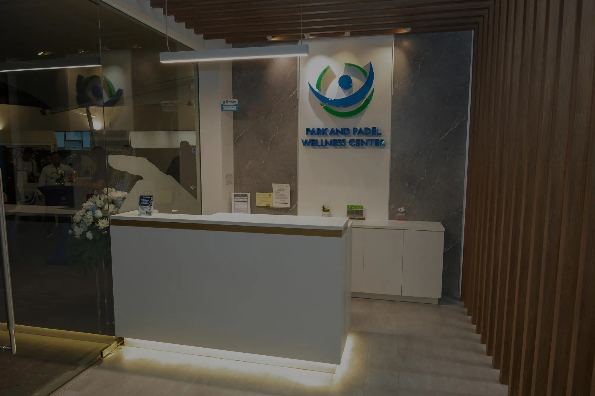 Recepción de Park and Padel Wellness Center con logo iluminado